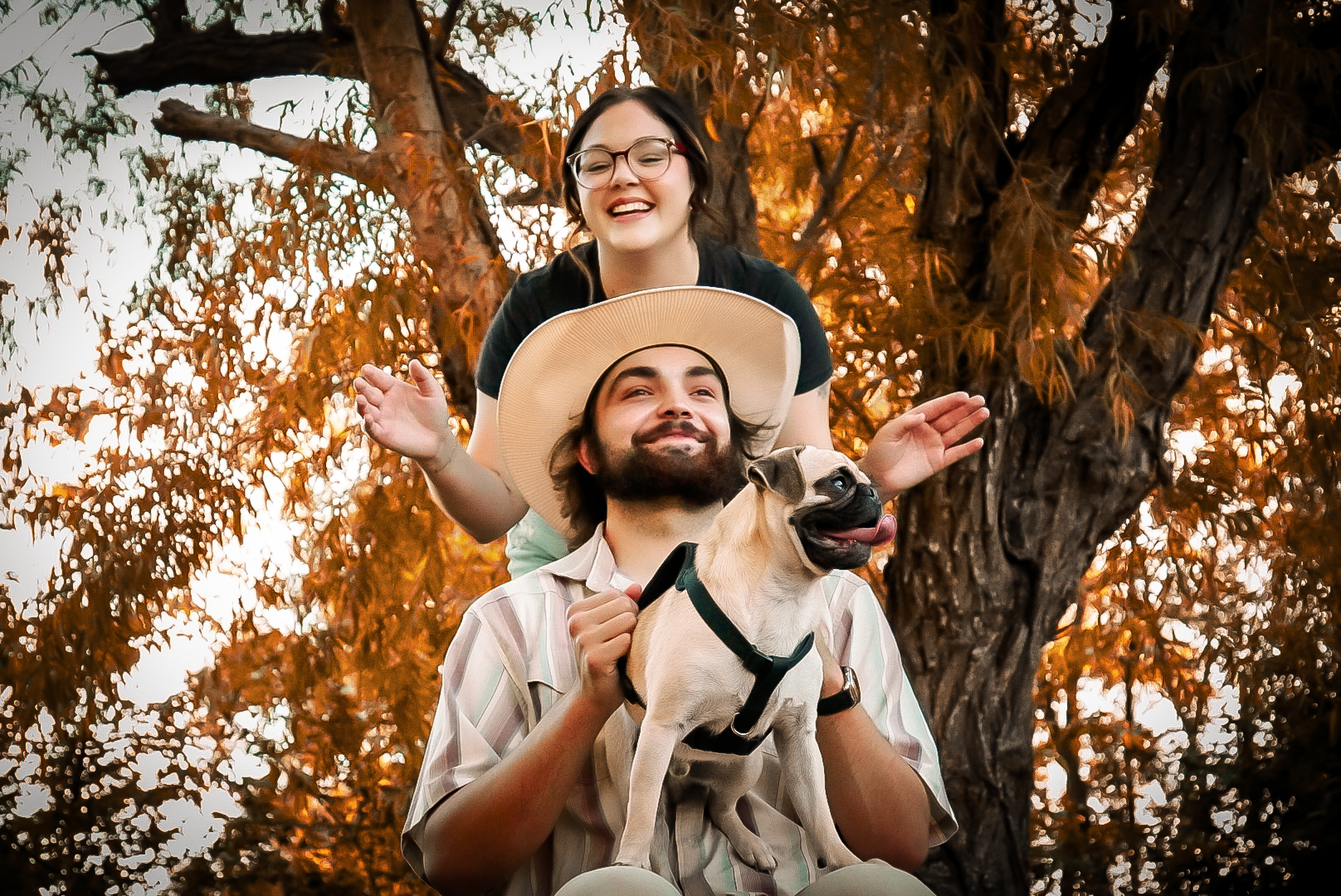 Couple with pug in golden autumn light