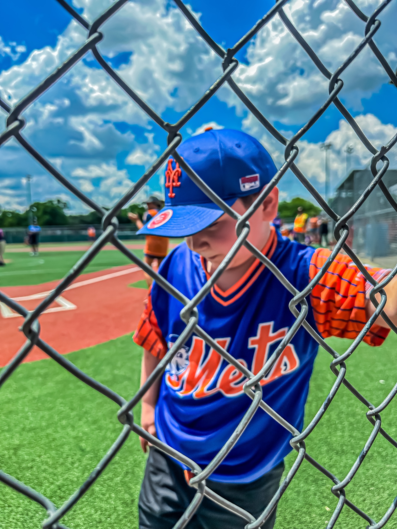 Youth baseball portrait shot through a chain-link fence
