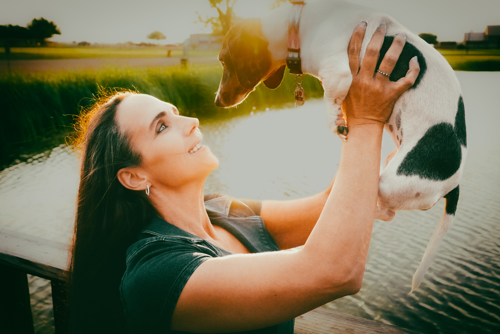 Woman with her dog at sunset by the lake