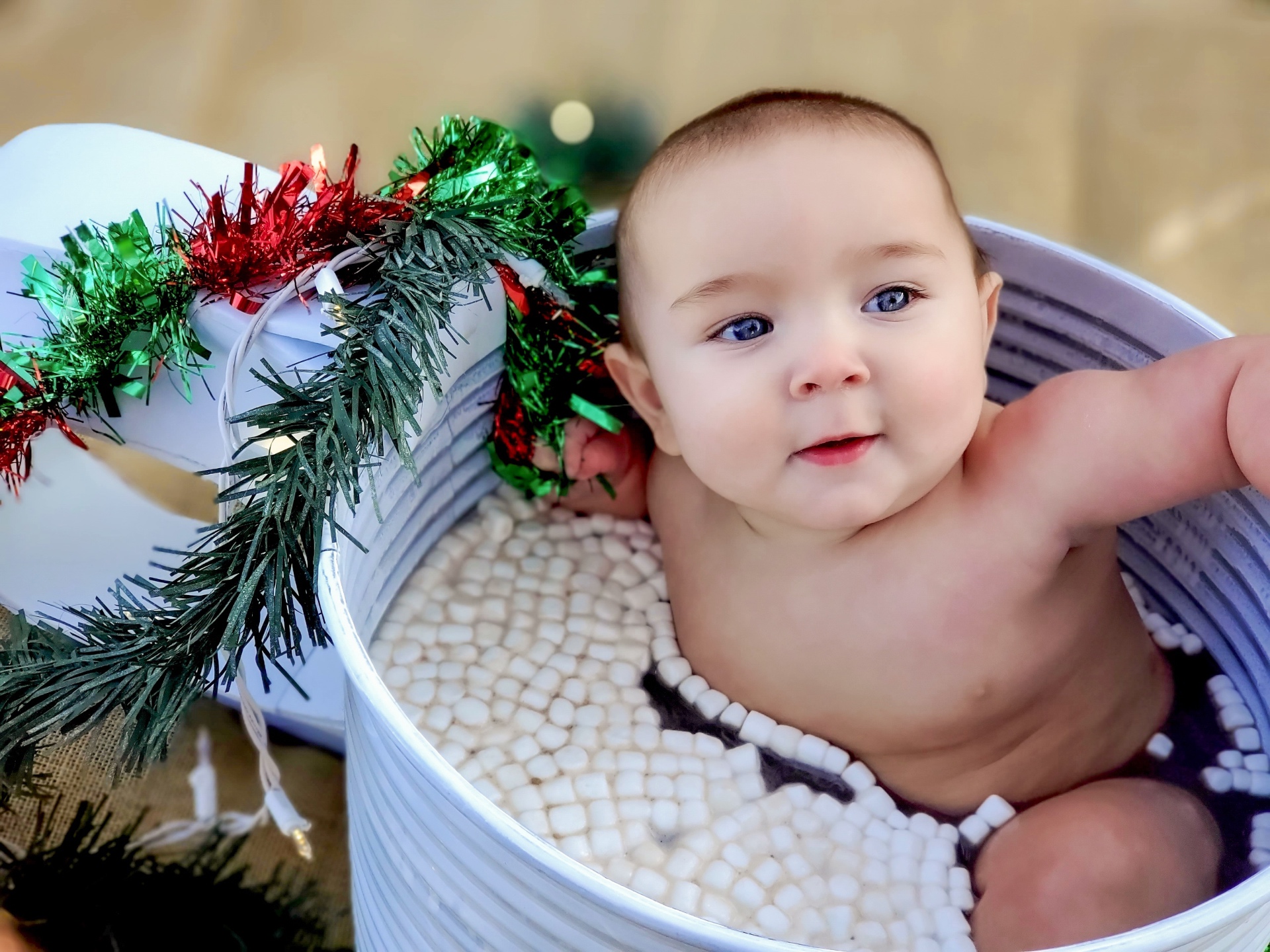 Baby portrait in a decorative tub with holiday garland