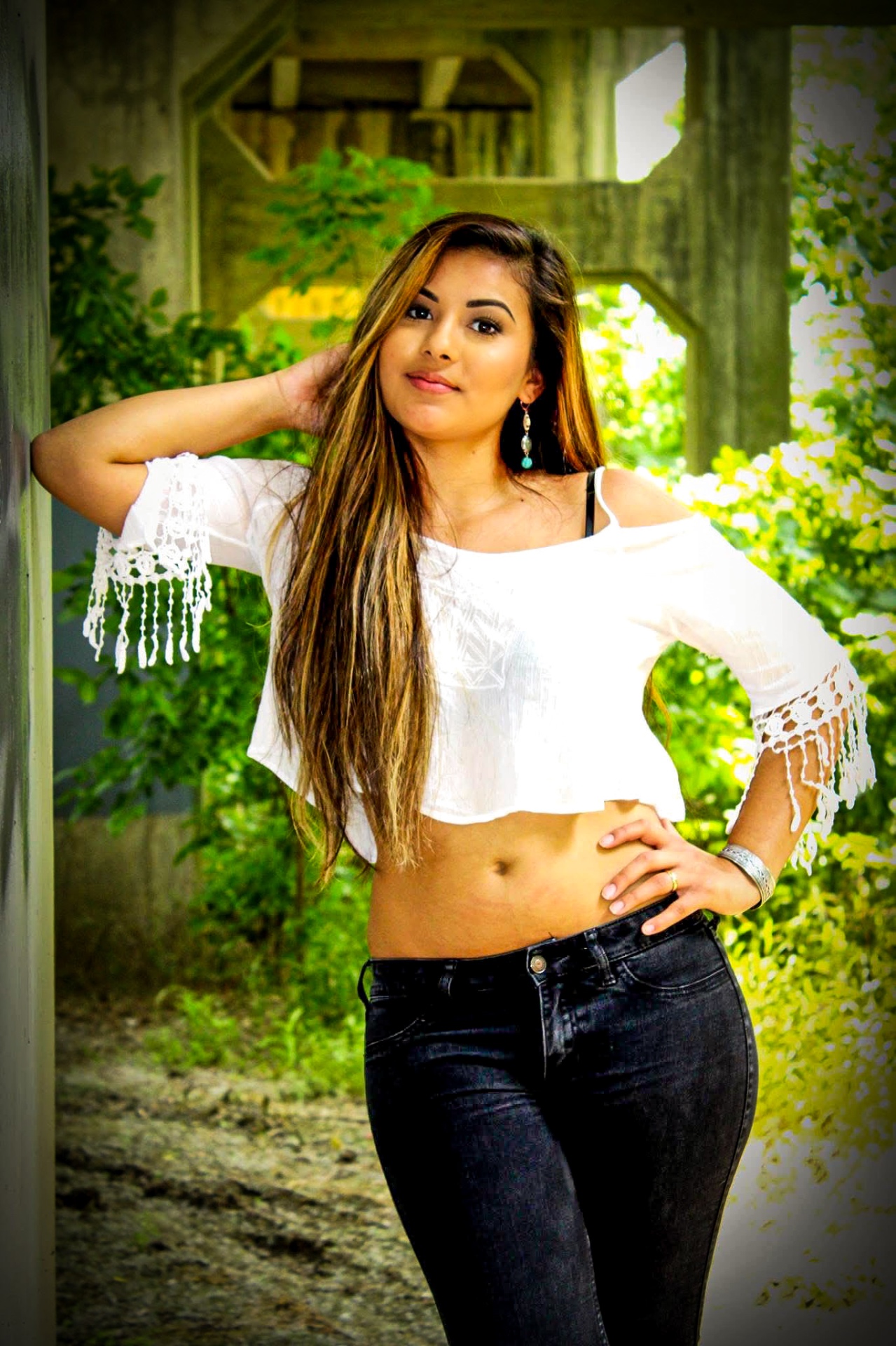 Portrait under a bridge in a white top and black jeans